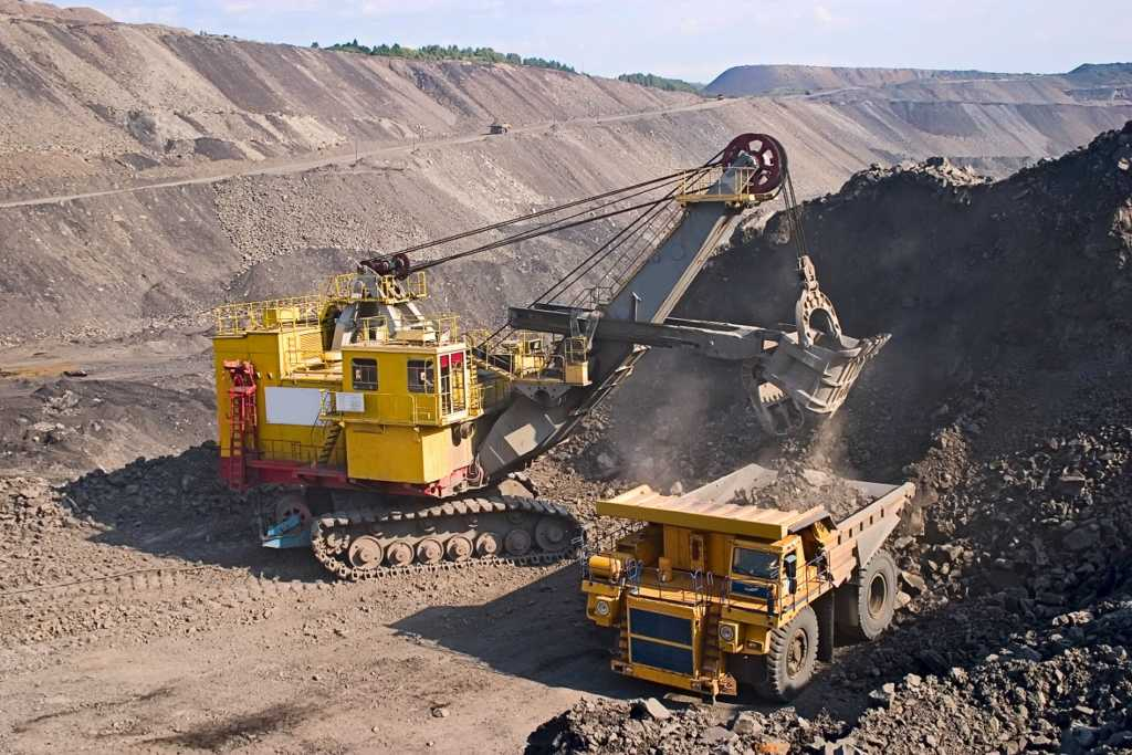 Dragline excavator loading a haul truck in an open-pit mine